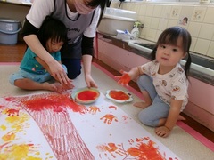 2歳児と1歳児が手形スタンプをしている写真