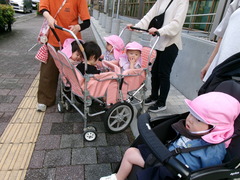 ０歳児が避難車に乗って散歩をしている写真