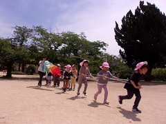 5歳児が公園で大きいこいのぼりをあげている写真