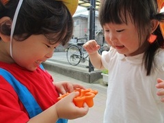 ダンゴムシを見つけて喜ぶ子どもの写真