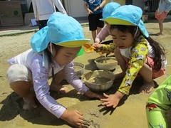 どろんこ遊びをする子どもの写真