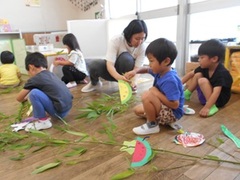 笹飾りをする子どもの写真