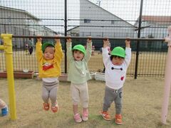1歳児が鉄棒にぶら下がっている写真