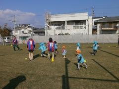 写真：先生と園児たちがサッカーをしている様子