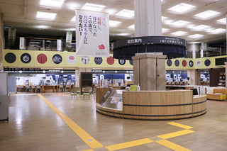 温泉の湯桶をイメージした番台風のカウンターに伊予かすりの暖簾を掛けた総合案内所の写真